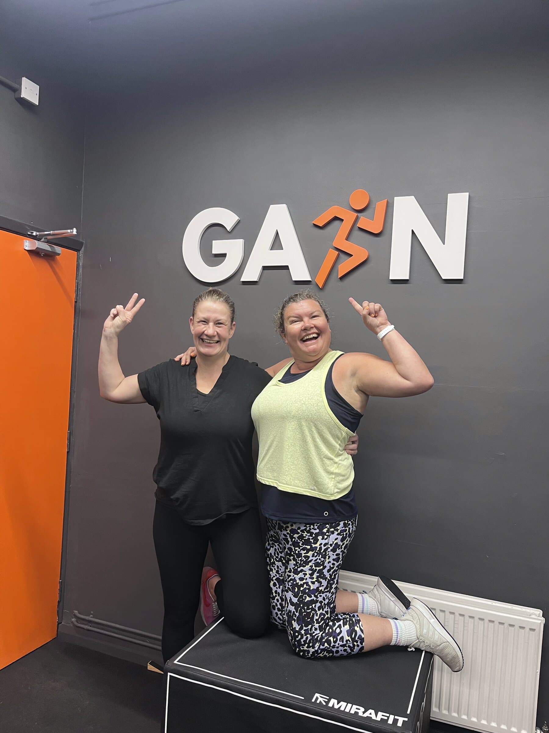 Two members hugging at GAIN sign